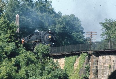 Steam Locomotive Passes Marker, Charges Across Viaduct image. Click for full size.