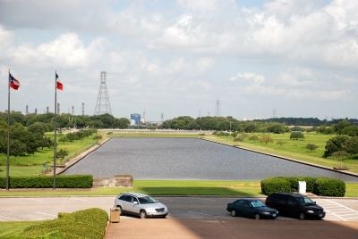 Visitor parking, reflection pond and two of the six flags that have flown over Texas. image. Click for full size.