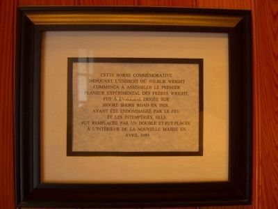 French translation of the brass plaque announcing the relocation. image. Click for full size.