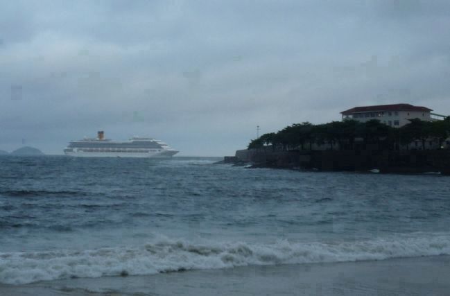 View from Copacabana Beach: a cruise ship off the promontory, departing Guanabara Bay image. Click for full size.