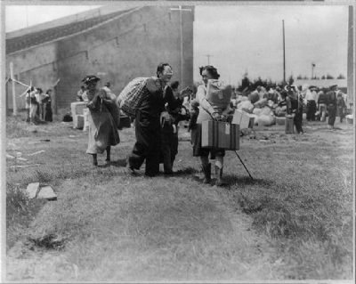 Two Japanese evacuee families meeting at assembly center, Salinas rodeo grounds image. Click for full size.