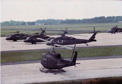 A lone UH-1 parked along with a group of U.S. Army's UH-60 Black Hawks image. Click for full size.