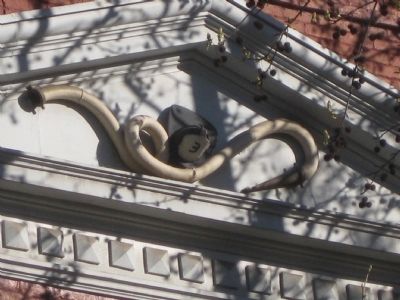 Firehose and shield with "3" - detail of south pediment image. Click for full size.