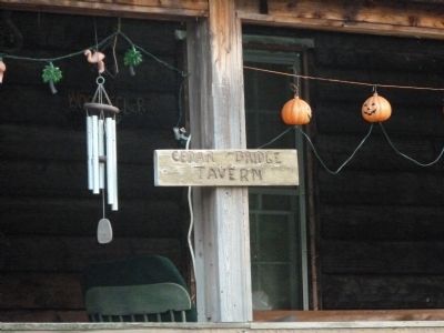 Wooden sign on tavern porch. image. Click for full size.