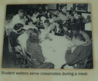 Student waiters serve classmates during a meal. image. Click for full size.