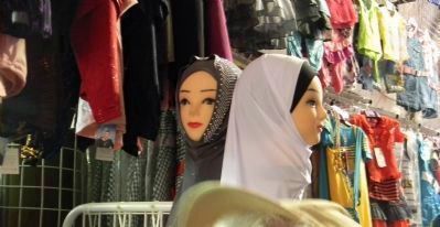 Hijabs for sale in a marketplace dress shop image. Click for full size.