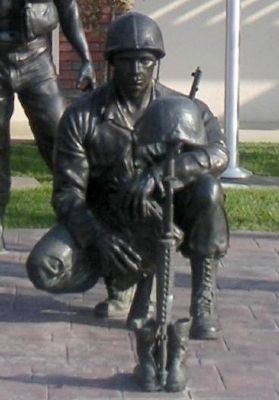 Soldier kneeling before the rifle, boots and helmet memorial image. Click for full size.