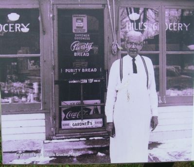 John Hill in front of his grocery store image. Click for full size.