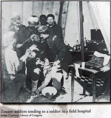 Zouave soldiers tending to a soldier in a field hospital image. Click for full size.
