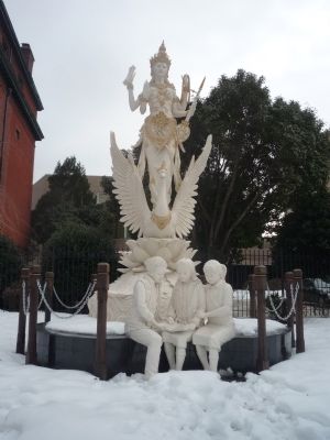 Saraswati Goddess - statue with three girls studying in the snow image. Click for full size.