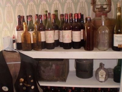 Collection of vintage wine bottles in the Cottage Corners bar image. Click for full size.
