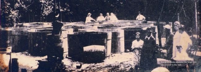 Local Residents examine the large vats discovered in the raid.. Click for full size. Local Residents examine the large vats discovered in the raid. image. Click for full size.