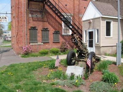 A WW II 75mm Pack Howitzer Stands In Front Of The Markers image. Click for full size.