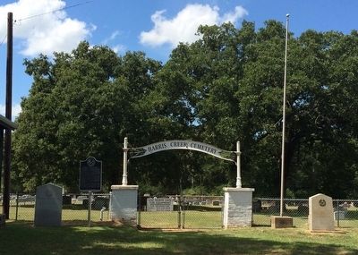 View of monument marker and cemetery entrance. image. Click for full size.