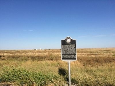 View of marker looking east at oil wells. image. Click for full size.