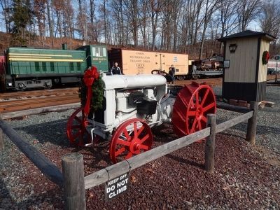 Tractor next to the Pennsylvania Railroad “Watch Box” Marker image. Click for full size.