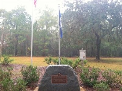 Fort King Burying Ground Marker with flags in background. Click for full size. Fort King Burying Ground Marker with flags in background image. Click for full size.