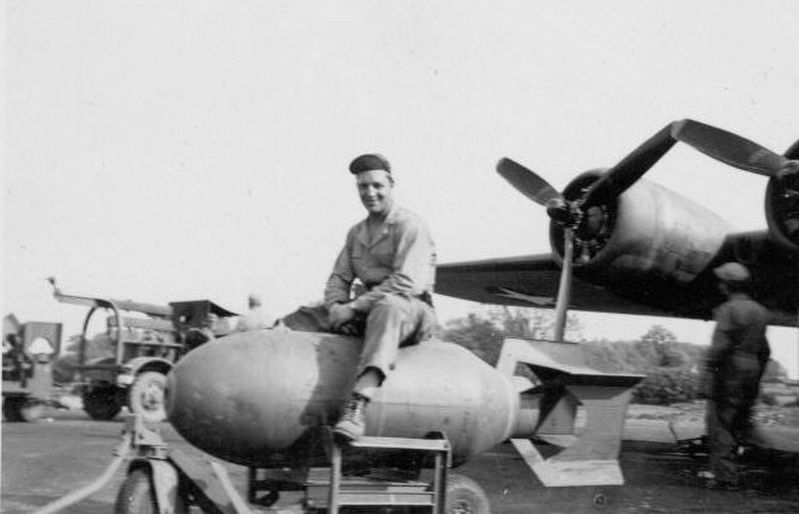 Ground crewman on a 2,000lb bomb during World War II. image. Click for full size.