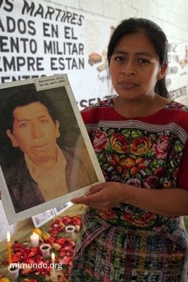 Angelica Chal shows a photo of her grandfather Benedicto Chal, murdered on April 24, 1981. image. Click for full size.