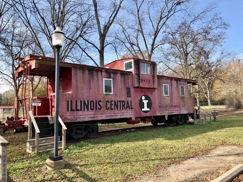 Illinois Central Railroad boxcar next to depot. image. Click for full size.