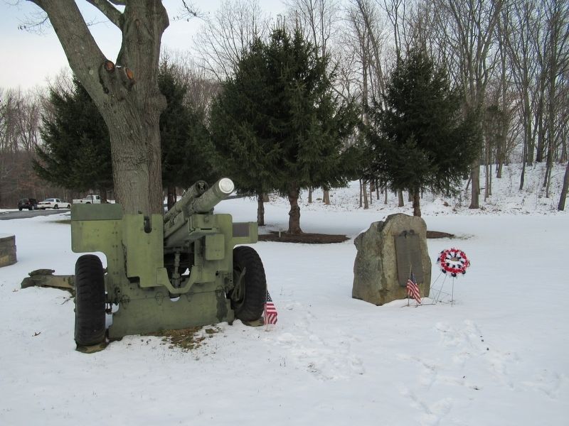 A 105mm Howitzer stands next to the Roll of Honor image. Click for full size.