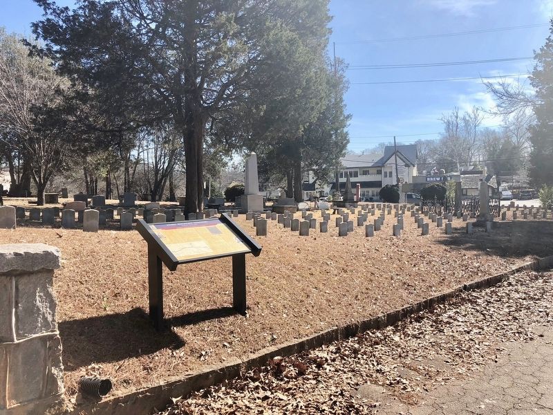 View of marker with grave markers of the Unknown Confederate soldiers in background. image. Click for full size.