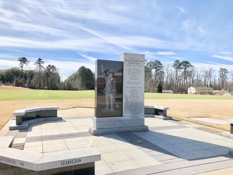Monument near parade field with WWII Company Street in far background. image. Click for full size.