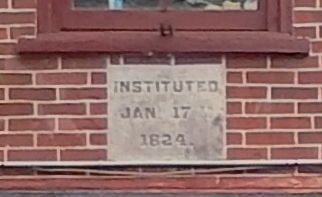 "Instituted Jan 17 1824" cornerstone, embedded in brick, 2nd floor image. Click for full size.