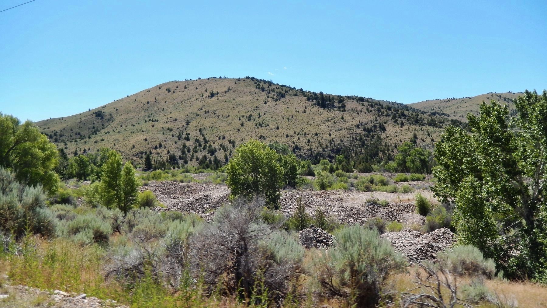 Large gravel piles west of marker are the tailings of gold dredging operations that occurred here. Click for full size. Large gravel piles west of marker are the tailings of gold dredging operations that occurred here image. Click for full size.