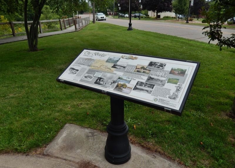The Bridge Marker (<i>wide view; Putnam Street and current Red Cedar River bridge in background</i>) image. Click for full size.