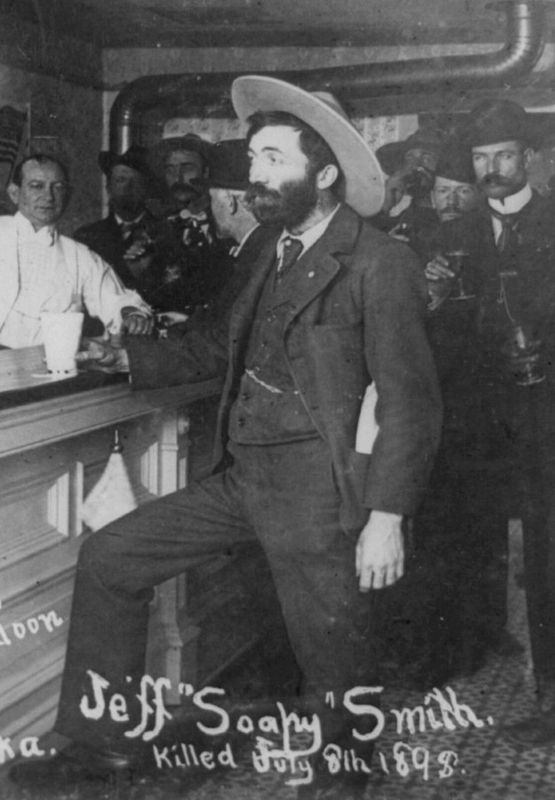 Jefferson “Soapy” Smith standing at bar in saloon in Skagway, Alaska. July 1898 image. Click for full size.