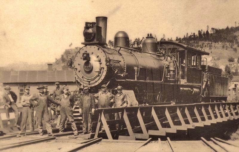 Marker (Panel 1) detail: mechanics & locomotive on turntable image. Click for full size.