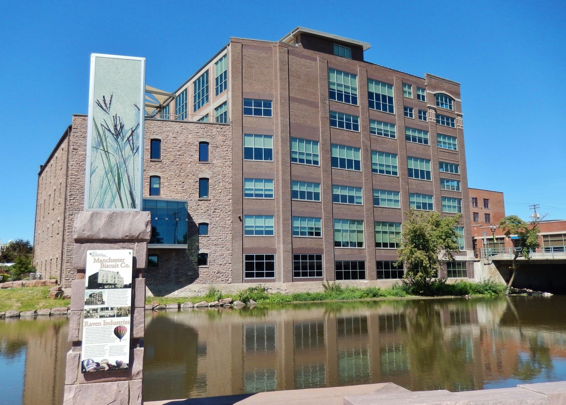 Raven Industries Marker (<i>wide view; Raven Industries building across river, in background</i>) image. Click for full size.