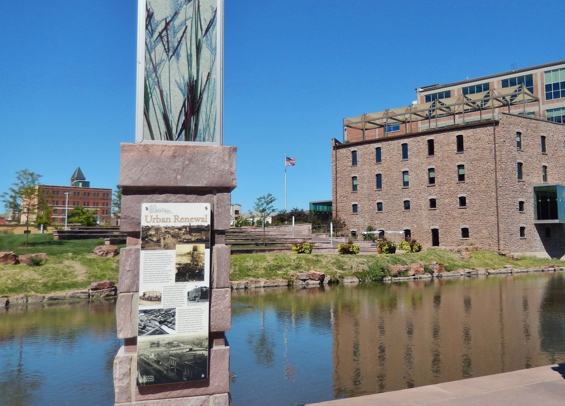 Urban Renewal Marker (<i>wide view; Big Sioux River and Raven Industries building in background</i>) image. Click for full size.