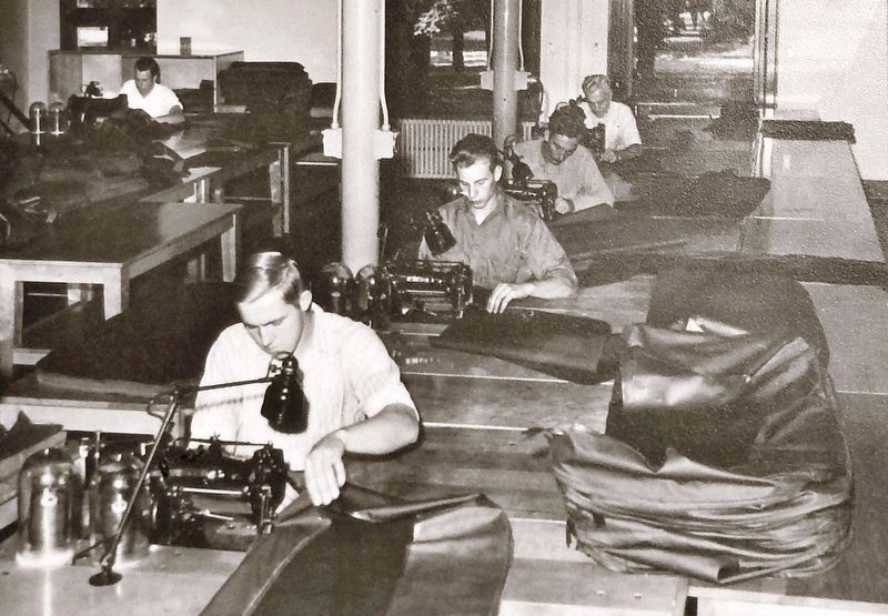 Marker detail: Workers assemble vehicle seat cushions within the former school building, early 1940s image. Click for full size.