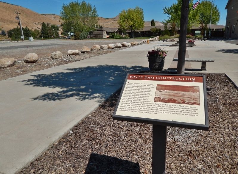 Wells Dam Construction Marker (<i>wide view looking north; north mall parking lot on left</i>). Click for full size. Wells Dam Construction Marker (<i>wide view looking north; north mall parking lot on left</i>) image. Click for full size.