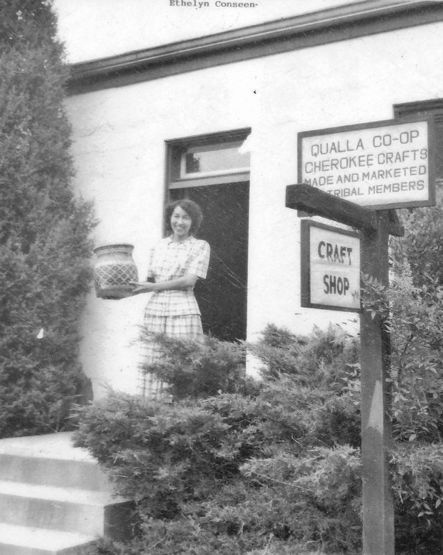 Marker detail: Ethelyn Conseen holds a rivercane basket at the entrance to Qualla Arts and Crafts. Click for full size. Marker detail: Ethelyn Conseen holds a rivercane basket at the entrance to Qualla Arts and Crafts image. Click for full size.