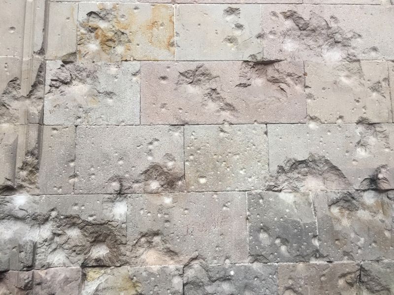 Shrapnel marks visible on the exterior wall of the church image. Click for full size.