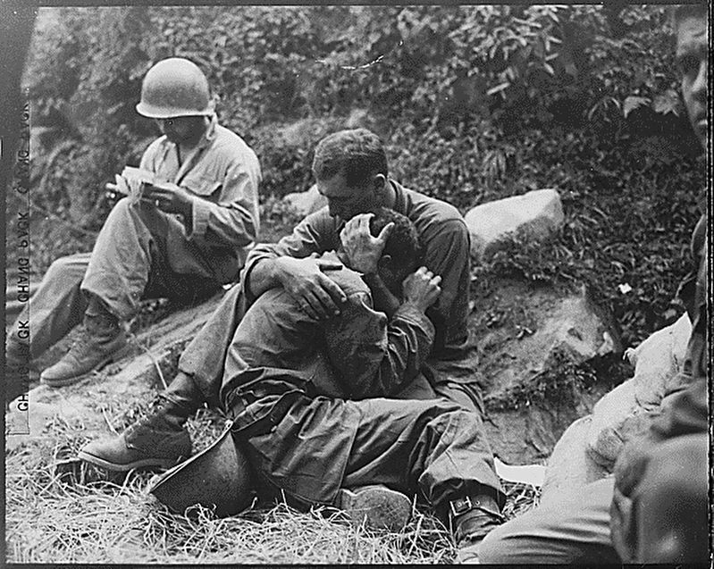 A grief stricken American infantryman whose buddy has been killed in action is comforted by another image. Click for full size.