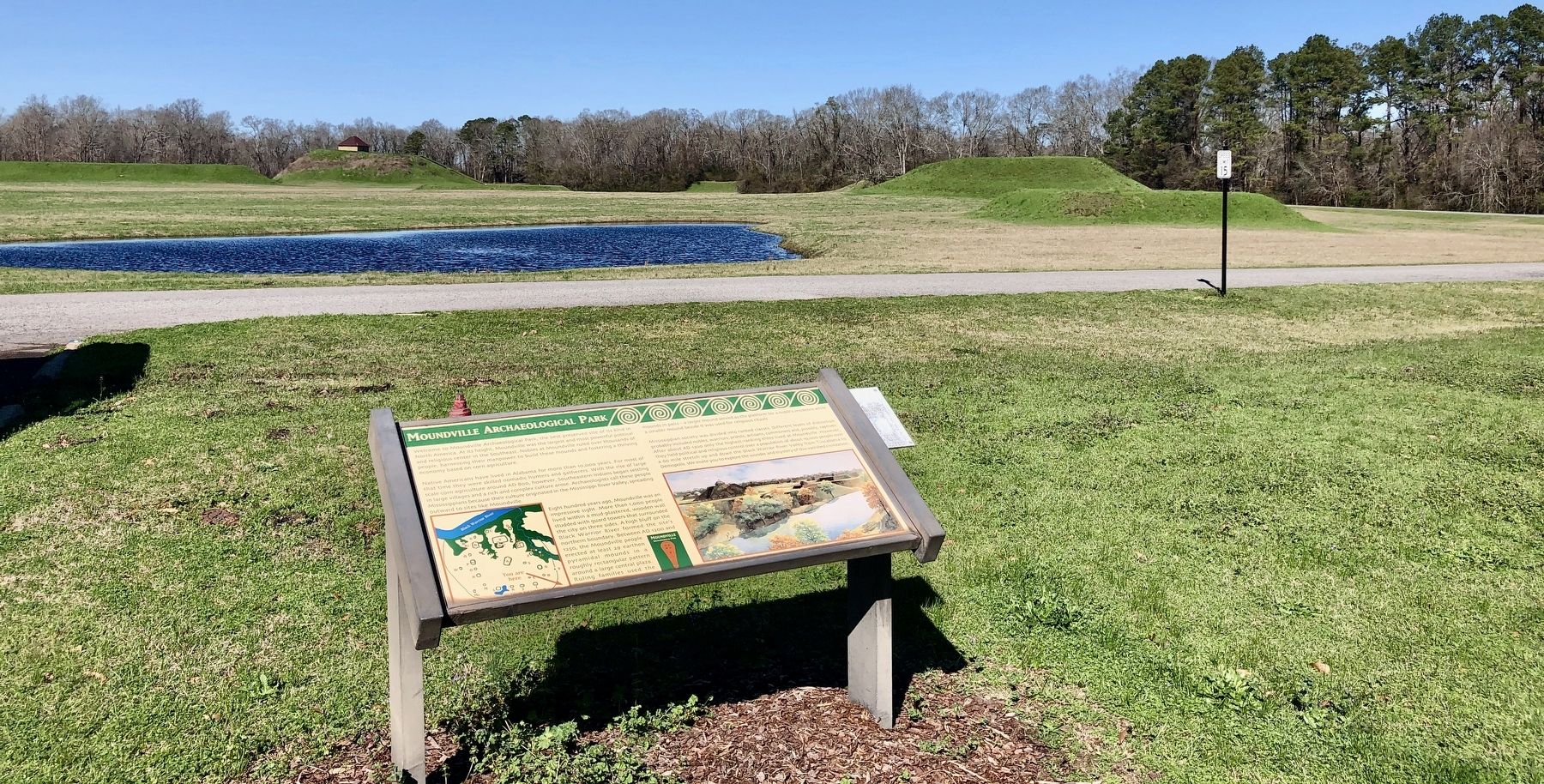 Moundville Archaeological Park Marker with mounds in background. image. Click for full size.