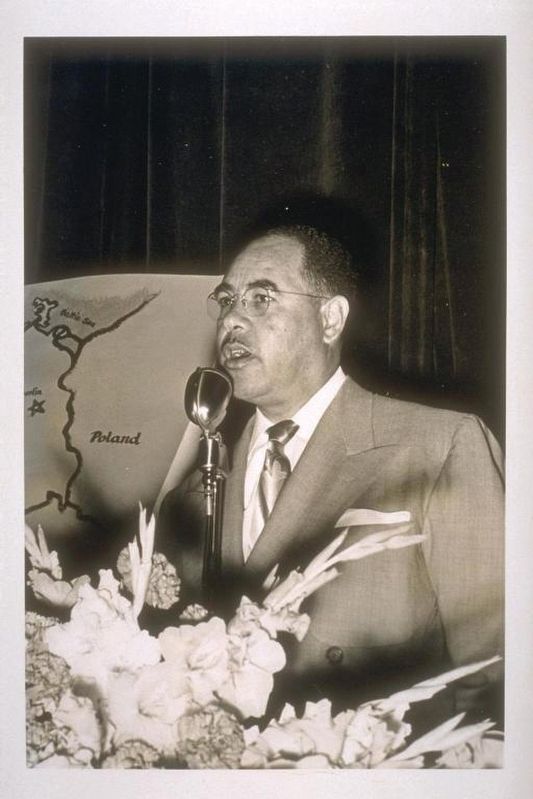 <i>William Byron Rumford speaking into a microphone.</i> image. Click for full size.