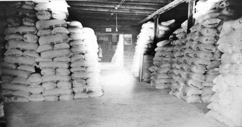 Marker detail: Mill warehouse crowded with local branded sacks awaiting commercial shipment. image. Click for full size.