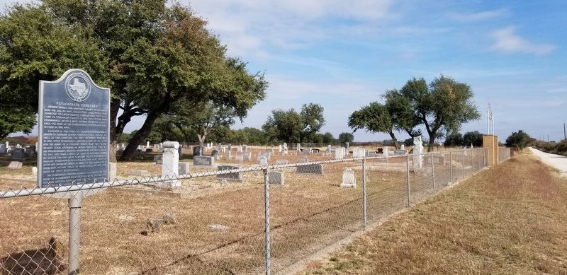 The marker is located along the road and fence of the cemetery. image. Click for full size.