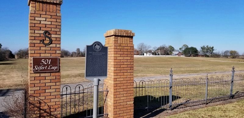 The homestead can be seen to the right of the The Holman-Seifert Homestead Marker in the photo image. Click for full size.