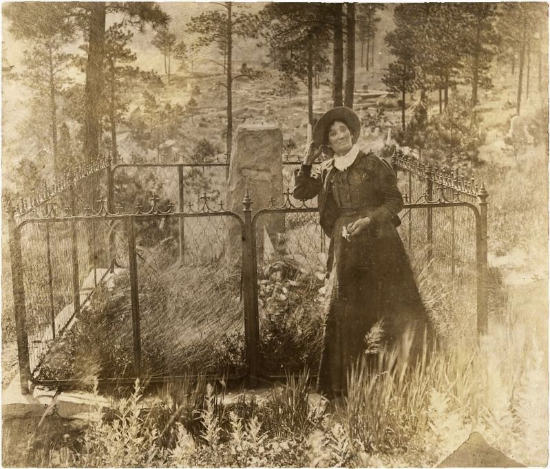 Martha "Calamity Jane" Canary at the grave of Wild Bill Hickok; she was buried next to him. image. Click for full size.