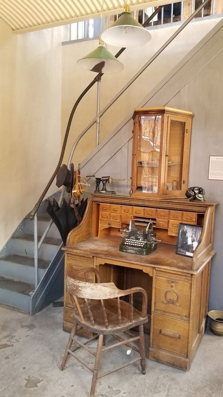 Jailer’s first floor desk with stair to upper floor jail cells image. Click for full size.