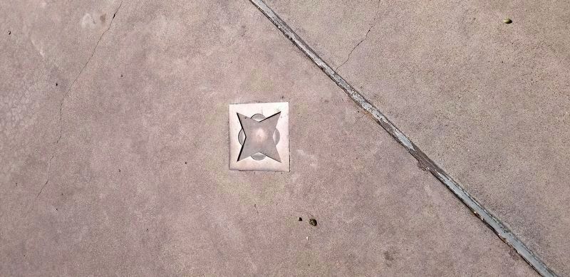 The bronze marker on the floor at the site of the first mineral water well image. Click for full size.