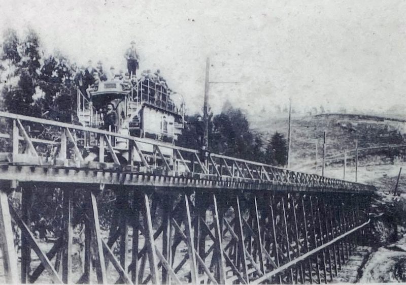 Marker inset: <i> Train trestle near Holman and Grosvenor Place circa 1895</i> image. Click for full size.