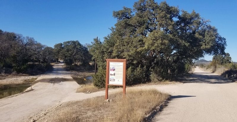 The view of the Welcome to Polly, Tx Marker from the road by the creek image. Click for full size.