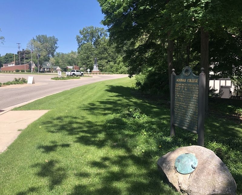 Aquinas College Marker with the statue of Thomas Aquinas in the distance image. Click for full size.
